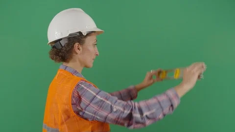Woman engineer using a level on green screen studio isolated shot against green Stock Footage 119664219