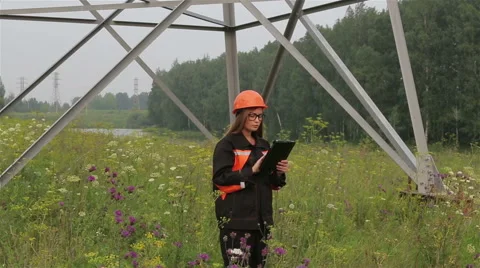 Woman engineer working near an electrical substation lines, power lines, teamwor Stock Footage 65373053
