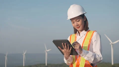 Woman engineer working with tablet on wind turbine propeller background. Video stock 221577863