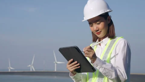 Woman engineer working with tablet on wind turbine propeller background. Video stock 251559914