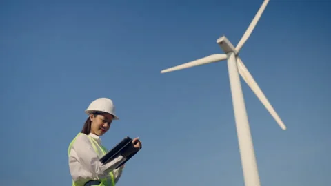 Woman engineer working with tablet on wind turbine propeller background. 스톡 동영상 251559980