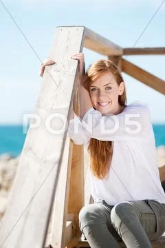 Woman enjoying the coastal sunshine Stock Photos