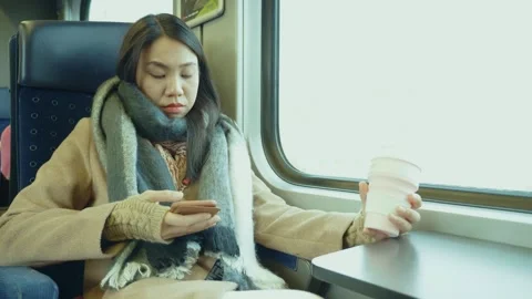 Woman Enjoying Coffee While Using Phone on Train Stock Footage 313830250