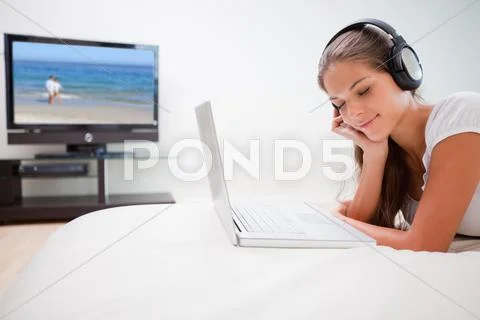 Woman enjoying music on her laptop Stock Photos