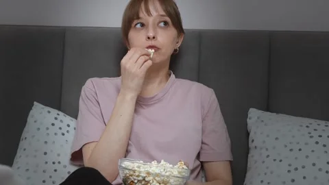 Woman enjoying popcorn while watching movie in bed Stock-Footage 313296511