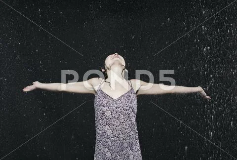 Woman Enjoying In Rain, Arms Outstretched.
