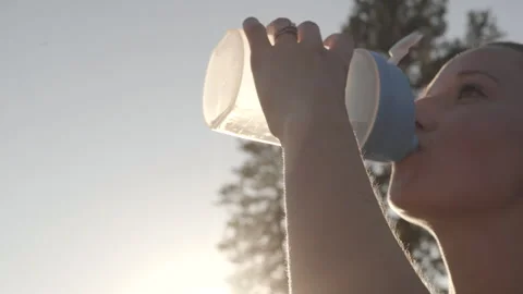 Woman enjoying refreshing sunlight while drinking water during workout Stock Footage 312723134
