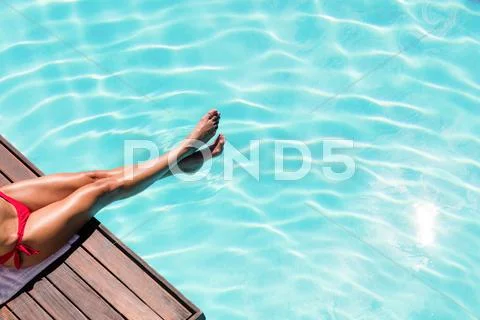 Woman enjoying sunbath on the pool edge on a sunny day Stock-Fotos