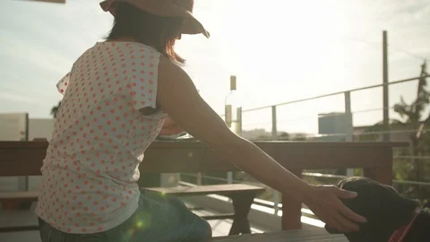 Woman enjoying wine at sunset with dog handheld slow-motion Stock Footage