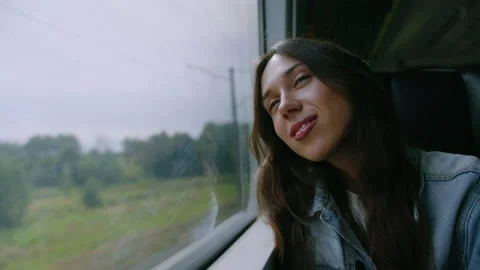 A woman enjoys a train ride looking out the window Stock Footage