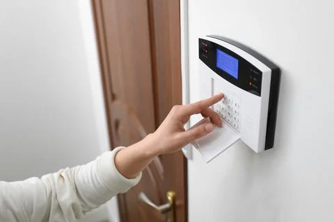 Woman entering code on home security system near door, closeup Stock Photos