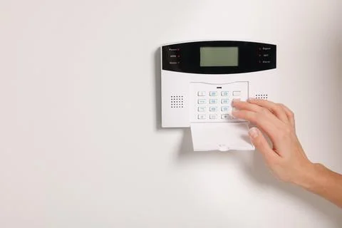 Woman entering code on home security system, closeup. Space for text 스톡 사진