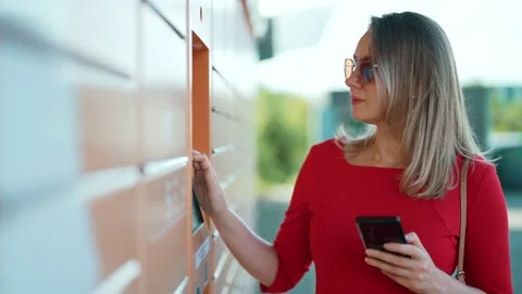 Woman entering code to pickup mail from automated postal machine. Stock Footage 203975234