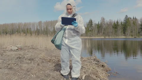 Woman is environmental inspector is using tablet PC near to lake Stock Footage 333503535
