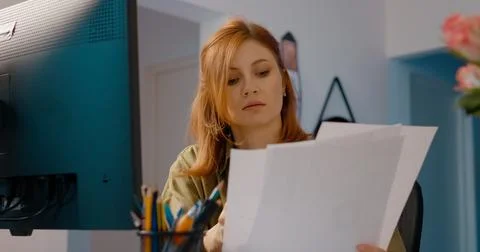 Woman evaluating data during a video call in her home office workspace Stock Photos