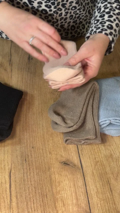 A woman examining a set of socks in different colors. Making a purchase rev.. Stock Footage 327830327