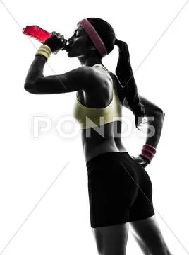 Woman exercising fitness drinking energy drink silhouette Stock Photos