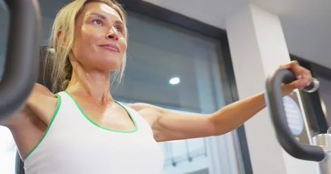 Woman Exercising on Machine in Gym Setting Stock Footage 323823430