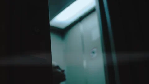 Woman exits from the elevator and going to a dark hall alone. Poor light in the Video stock 252235405