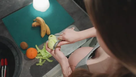 Woman expecting drinks showing nutritious fruit preparation process. Expecting Stock Footage 333403384
