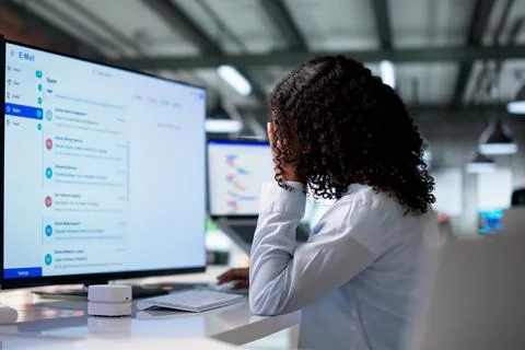 Woman Experiences Headache While Working Stressed At Her Computer Desk. Фото