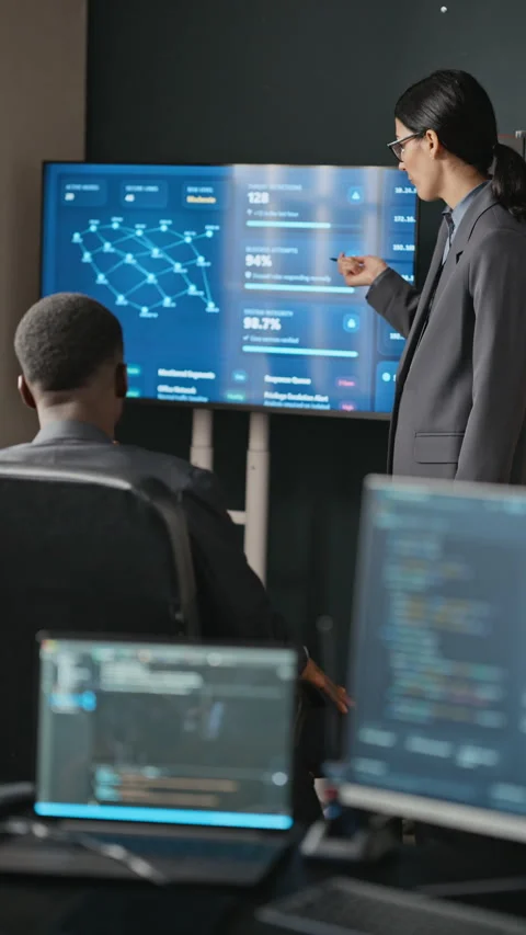 Woman Explaining Cyber Security Data to Black Colleague in Office Stock Footage 346818732