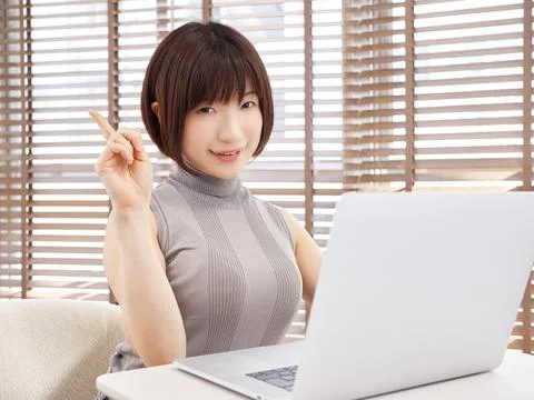 A woman explains the points of computer operation in a bright living room Stockfoto's