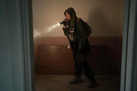 Woman explorer with flashlight inside corridor or tunnel of ruined industrial Stock Photos