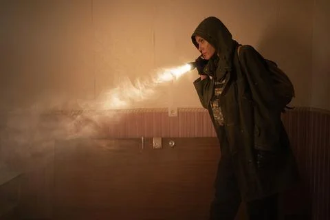 Woman explorer with flashlight inside corridor or tunnel of ruined industrial Stock Photos