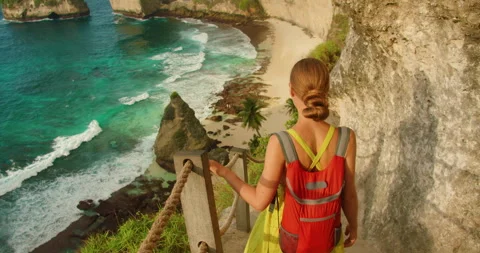 Woman explores cliffside path overlooking Diamond Beach and rocky coast in Nusa Video stock 341453018