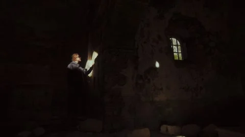 Woman exploring an abandoned structure with captivating light effects on the Stock Footage 313731614