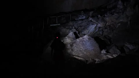 Woman exploring a dark cave Stock Footage 346113842