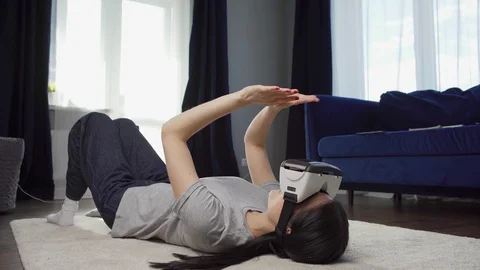 Woman exploring virtual reality lying on floor Video stock 128749043