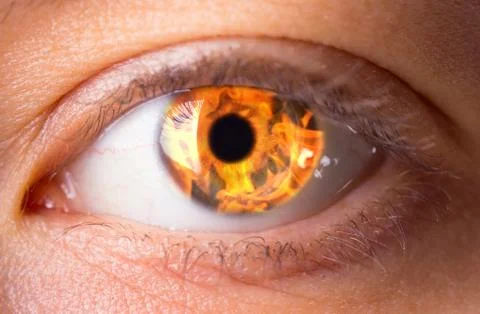 Woman eye with burning fire in it Stock Photos