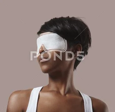 Woman with an eye mask, making an eye treatment and lines spread from mask Stock Photos