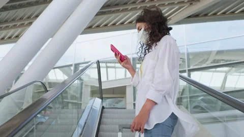 Woman with face mask is checking timetable of airport or railway station in Stock Footage 232414893