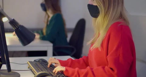 Woman in face mask using computer at desk in office Stock Footage 144268386