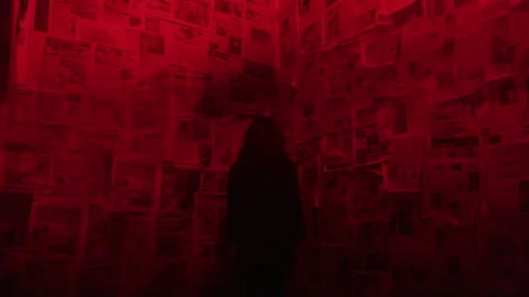 Woman Faces Corner of Strobing Distorted Red Room Covered in Newspaper Clippings Stock Footage 208794028