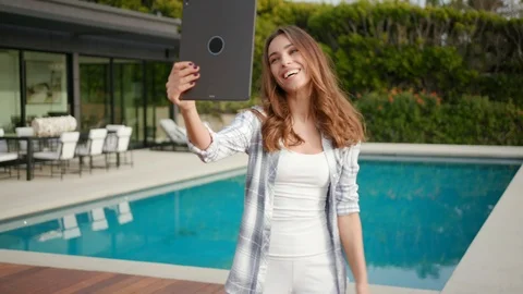 Woman FaceTime near pool using iPad Pro Stock Footage 101488811
