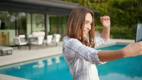 Woman FaceTime near pool using iPhone Vídeo Stock 101489108