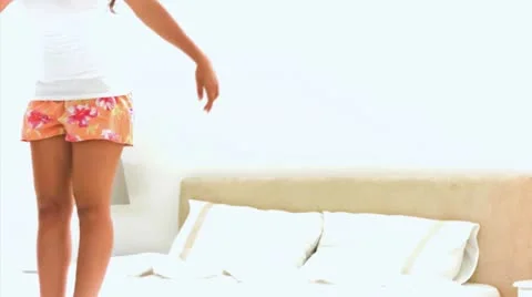 Woman falling back on her bed in slow motion Stock Footage