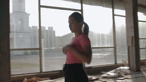 Woman falls on hands while dancing in abandoned hall Stock Footage 127649061