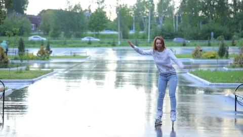 The woman falls on the rollers in park Stock Footage 82393695
