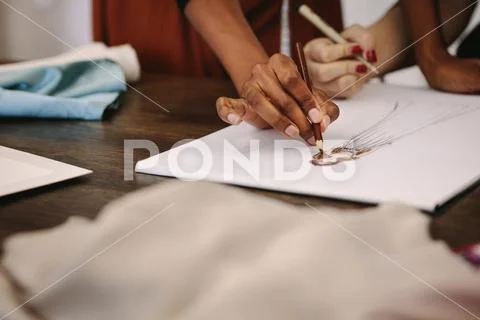 Woman fashion designers making designs on drawing paper Stock Photos