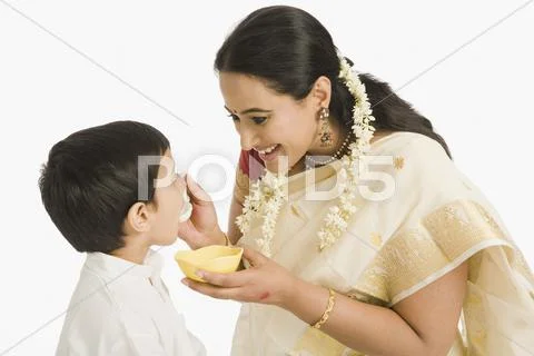 Woman feeding sweet to her son Stock Photos