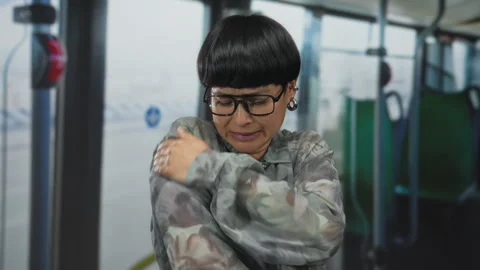 Woman feeling cold inside a bus while wearing glasses and a patterned jacke.. Stock Footage 313060164