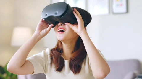 Woman feeling excited while using 360 VR headset for virtual reality, metaverse Stock Footage 189261670
