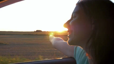 Woman feeling freedom while touching sun during road trip at sunset shines Stock Footage 306163462