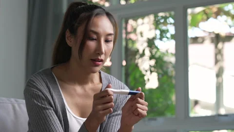 Woman feeling happy while looking at the positive results of a pregnancy test. Stock Footage 236868449