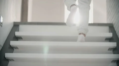 Woman feet walking up a white stairs at home Stock Footage